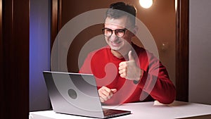 Like. Happy young programmer freelancer man with glasses working on laptop