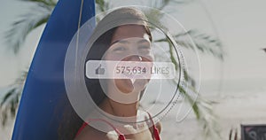Like icons with increasing numbers against portrait of woman with surfboard smiling at the beach