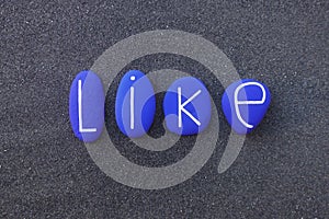 Like text with blue colored stones over black volcanic sand