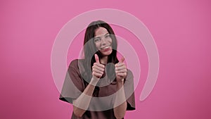 Like. Thumbs up gesture. Happy young woman showing Thumbs up gesture on pink background gives different emotions