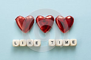 Like time words, made of wooden letters with red heart on blue background. Social media concept