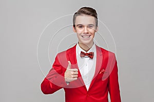 Like, well done. Portrait of trendy elegant gentleman showing thumbs up gesture, approval sign