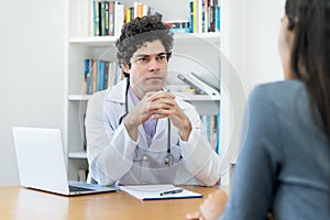 Likeable doctor listening to problems of female patient