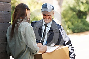 She likes his package. Shot of a courier delivering a package to a young woman.