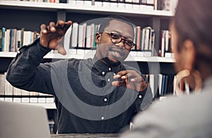 He likes to get every detail across. a handsome young male architect having a discussion with his colleague in a modern