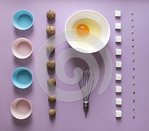 Lilac background food knolling walnut greek seeds sunflower sugar cube refined corolla egg in round bowl cake mold flour blue pink