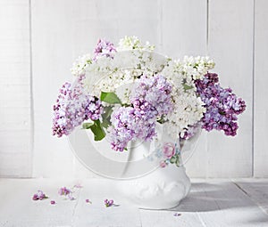 Lilac bouquet in ceramic jug.