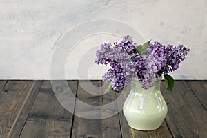 lilac branches in a clay vase on a wooden background. Beautiful lilac flowers. Spring blossom. spring or summer concept