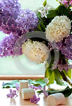 Lilac bunch in vase and marshmallows