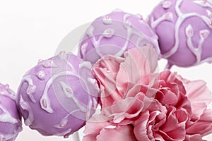 Lilac cake pops lavishly decorated with icing.