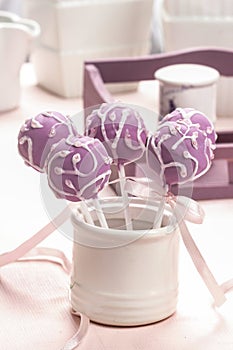 Lilac cake pops lavishly decorated with icing.