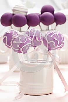 Lilac cake pops lavishly decorated with icing.