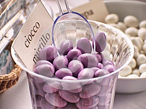 Lilac coriandoli in transparent basket at ceremony cioco translation chocolate, mirtillo translation blueberry
