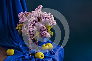 lilac flowers in a vase on a table against a blue background