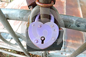 Lilac heart-shaped lock on the railing , sign of eternal love of the newlyweds