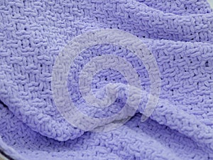 Lilac knitted plaid close-up. Background. Creases on soft surfaces