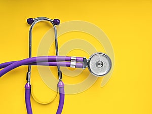 Lilac medical phonendoscope close up on yellow background