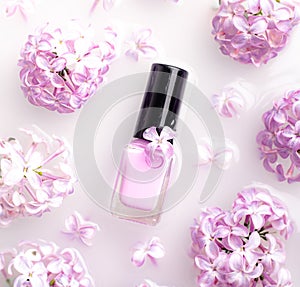 Lilac nail polish and a branch of lilac . A bottle of nail polish without a name. The concept of advertising the