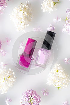 Lilac nail polish and a branch of lilac . A bottle of nail polish without a name. The concept of advertising the