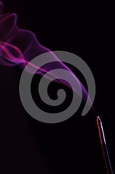 Lilac smoke incense sticks on a black background