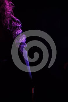 Lilac smoke incense sticks on a black background