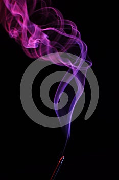 Lilac smoke incense sticks on a black background