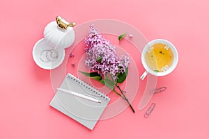 Lilas flowers bouquet with cup tea and notepad top view