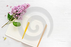 Lilas flowers bouquet with cup tea and notepad top view