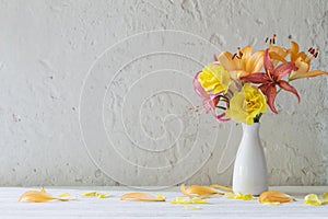 the lilies and roses in white vase on white background