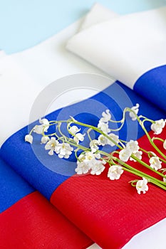 lilies of the valley against the background of the flag of russia, copy space. Postcard for the holiday Day of Russia.