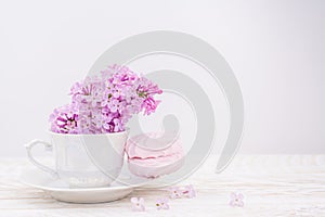 Lillac in cup on lilac background  and marshmallow