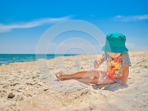 Lilltle boy playing on the seaside in summertimes. Baby having fun with the sand. Summer rest concept. Happy childhood