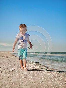 Lilltle boy playing on the seaside in summertimes. Baby having fun with the sand. Summer rest concept. Happy childhood