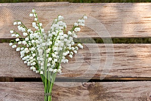 Lilly of the valley flowers on wooden background.