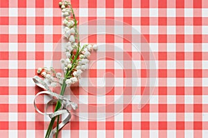 Lilly of valley on red checked pattern background photo