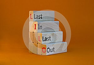 LILO last in last out symbol. Concept words LILO last in last out on wooden blocks. Beautiful orange table, orange background.