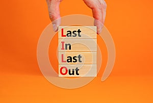 LILO last in last out symbol. Concept words LILO last in last out on wooden blocks. Beautiful orange table orange background.