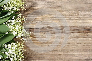 Lily of the valley flowers on wooden background.