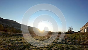 Limanowa, South Poland: Wide angle view of green grass meadow against polish mountains with sun rise through the hill Timelapse 4K