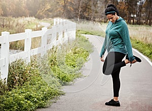 Limber legs coming right up. an attractive young woman stretching while out for a run in nature.