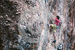 Climber overcomes a difficult climbing route on a natural terrain photo