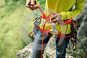 ÃÂ¡limber wearing safety harness making a eight rope knot