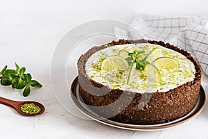 Lime cheesecake with peppermint. Cheesecake with cup of coffee on white background. Side view. Coffee house, confectionery concept