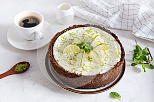 Lime cheesecake with peppermint. Cheesecake with cup of coffee on white background. Top view, copy space