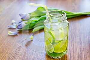 Lime cocktail in jar and bouquet of tulips