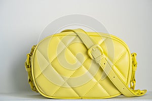 Lime cross body bag. Ladies bright-colored handbag on gray background. Yellow bag