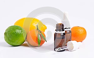 Lime essential oil in glass bottle and fresh green lime fruit isolated on white background