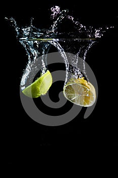 Lime fruit dropping in water photo