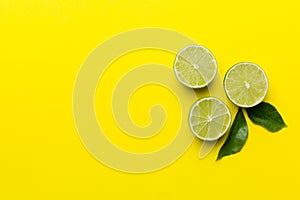 Lime fruits with green leaf and cut in half slice isolated on white background. Top view. Flat lay with copy space