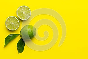 Lime fruits with green leaf and cut in half slice isolated on white background. Top view. Flat lay with copy space